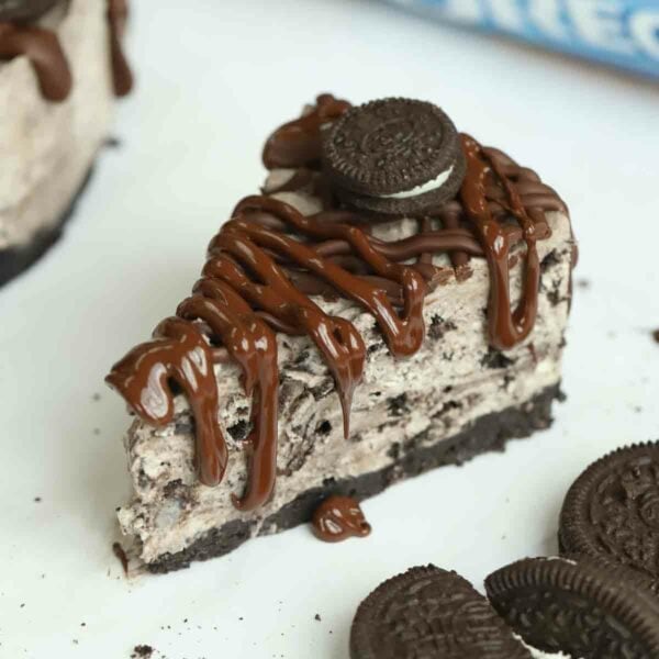 A close up of a slice of Oreo Cheesecake, ready to eat.