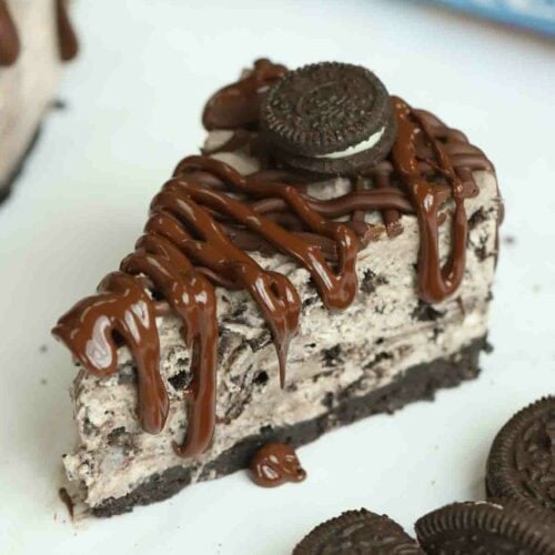 Sliced Oreo Cheesecake piece with Oreo's to the side.