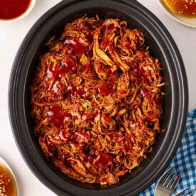 A close look at a pan filled with pulled pork in a slow cooker.