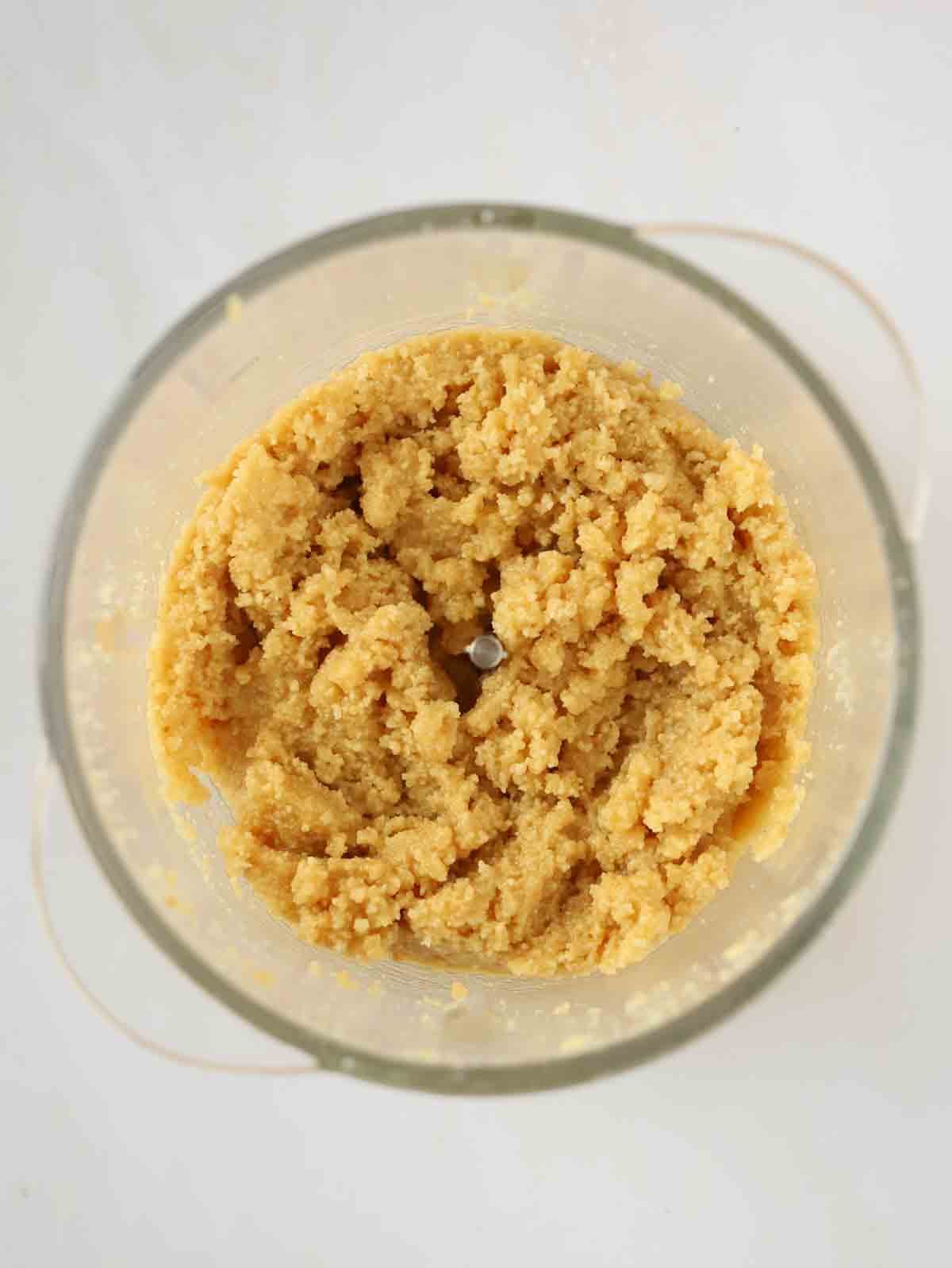 Shortbread biscuits crumbled up in a food processor for step 1 in the recipe for Vanilla Cheesecake.