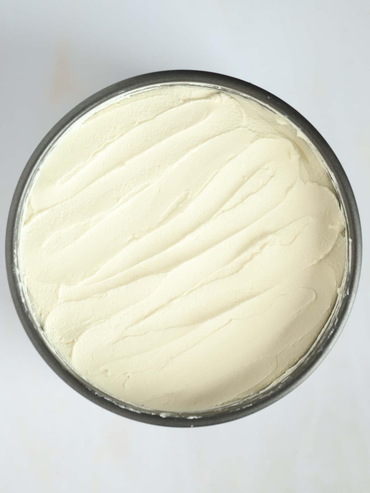 A tin filled with creamy cheesecake filling for step 4 in the process for Vanilla Cheesecake.