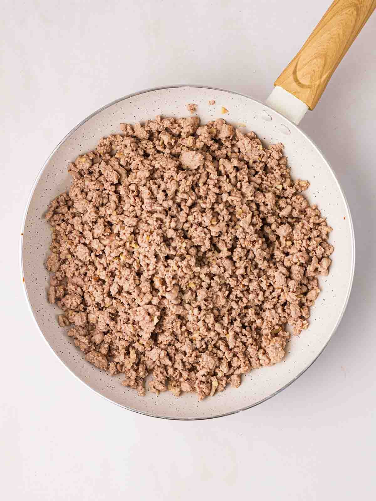 A white pan with cooked chicken mince inside for step 2 in the recipe for Cashew Chicken.