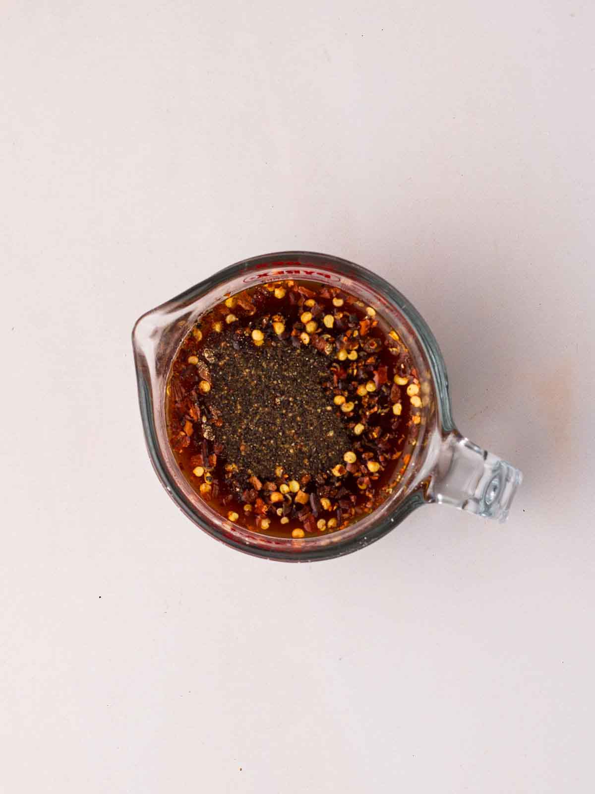 A bird's eye view of a glass jug filled with a dark sauce for step 3 in the process for Cashew Chicken.