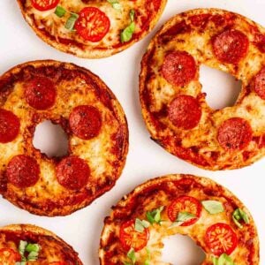 Pizza style bagels topped with pepperoni and tomatoes.