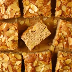 Squares of cooked apple cake with nutty topping.