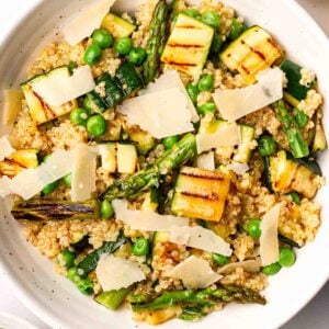 A bowl with quinoa, courgette, asparagus, peas and parmesan.