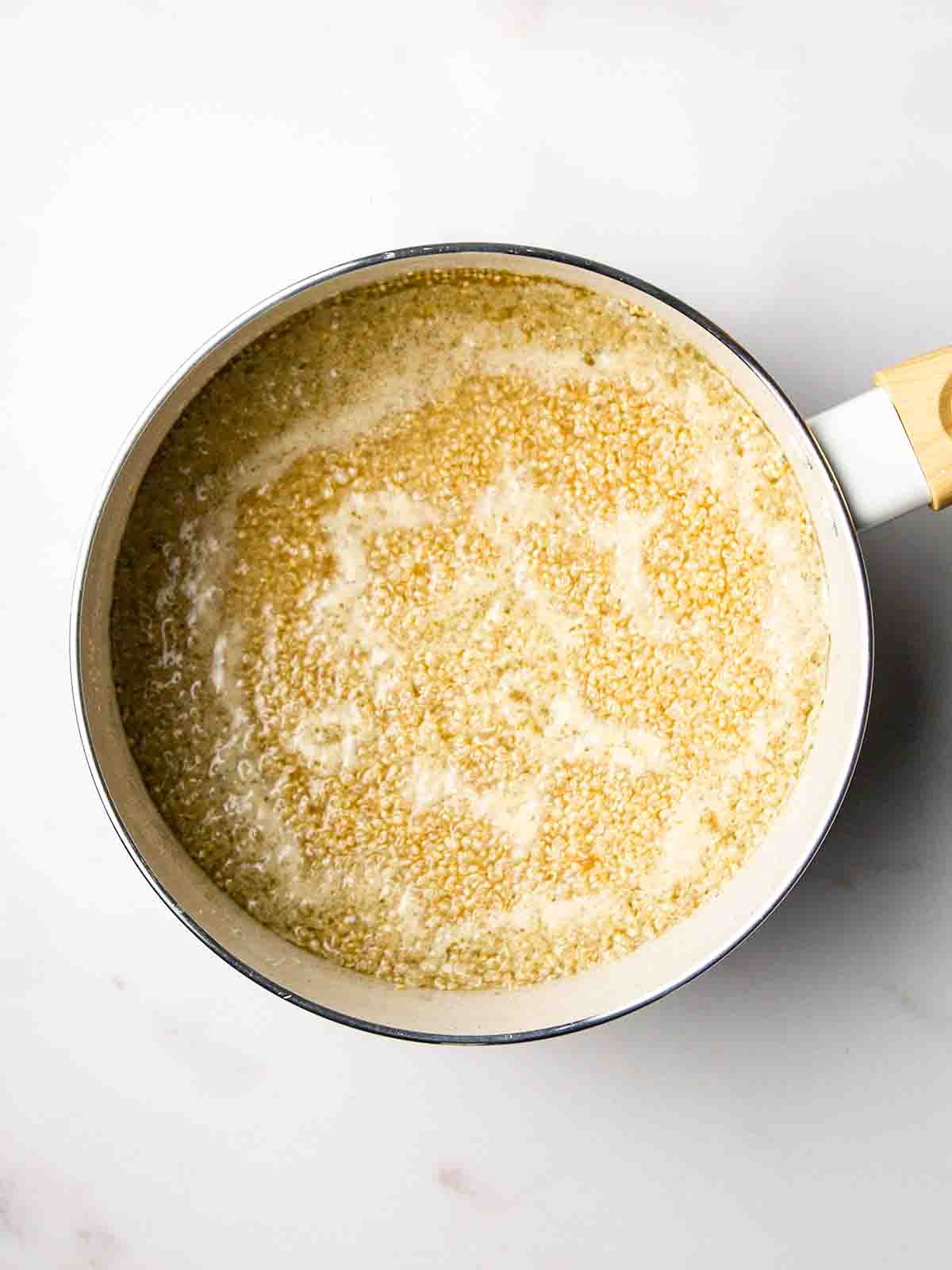 A pan filled with quinoa and water for step 1 in the recipe for Quinoa Salad.