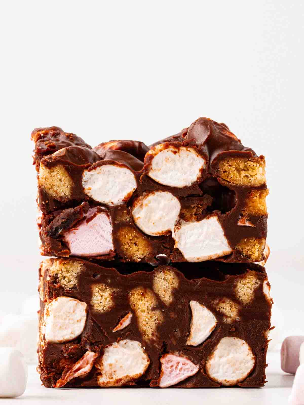 Two squares of rocky road from a side angle on top of each other.
