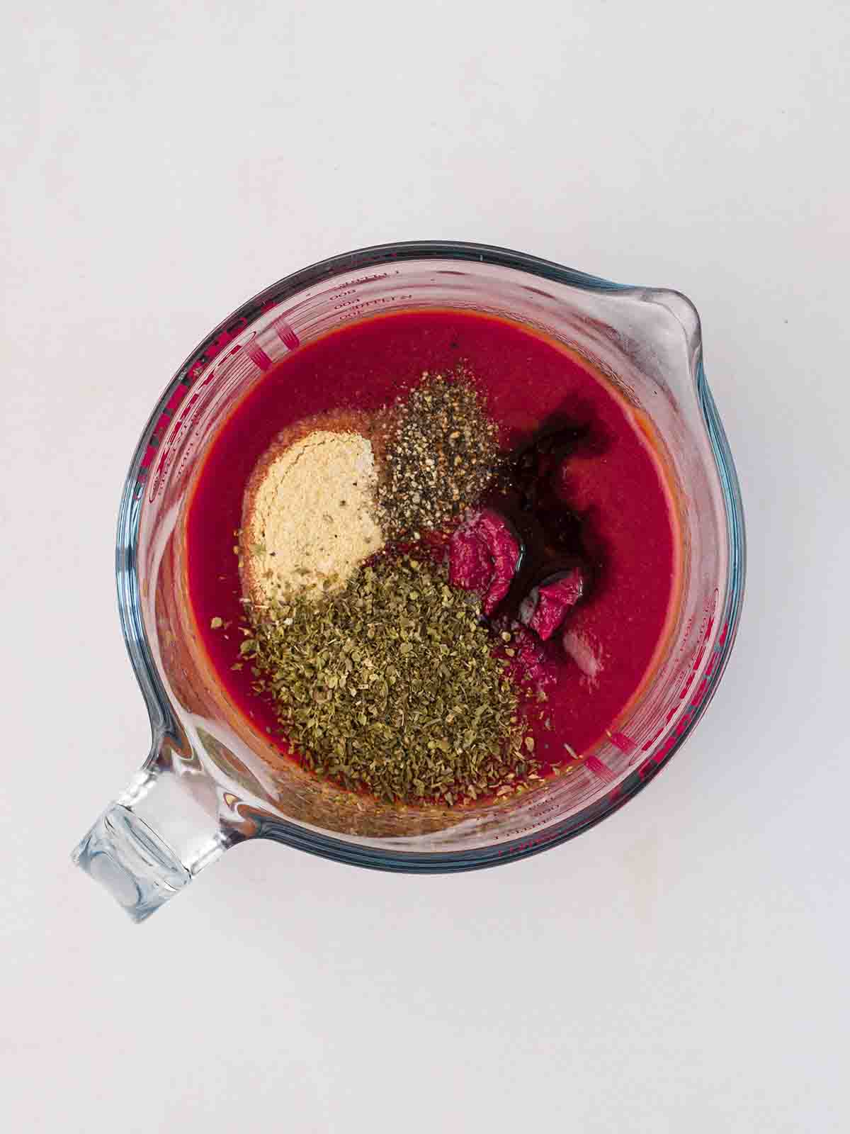 A glass jar filled with sauce ingredients for the recipe Tuna Pasta Bake.