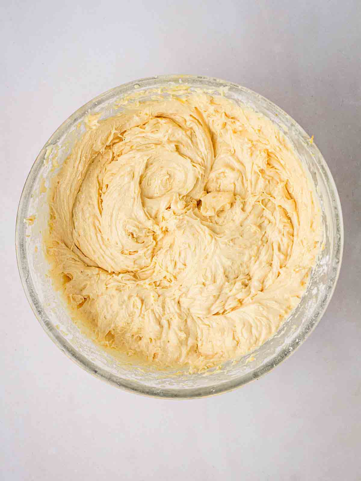 A cake mixture in a glass bowl for step 1 in the method for Orange Drizzle Cake.