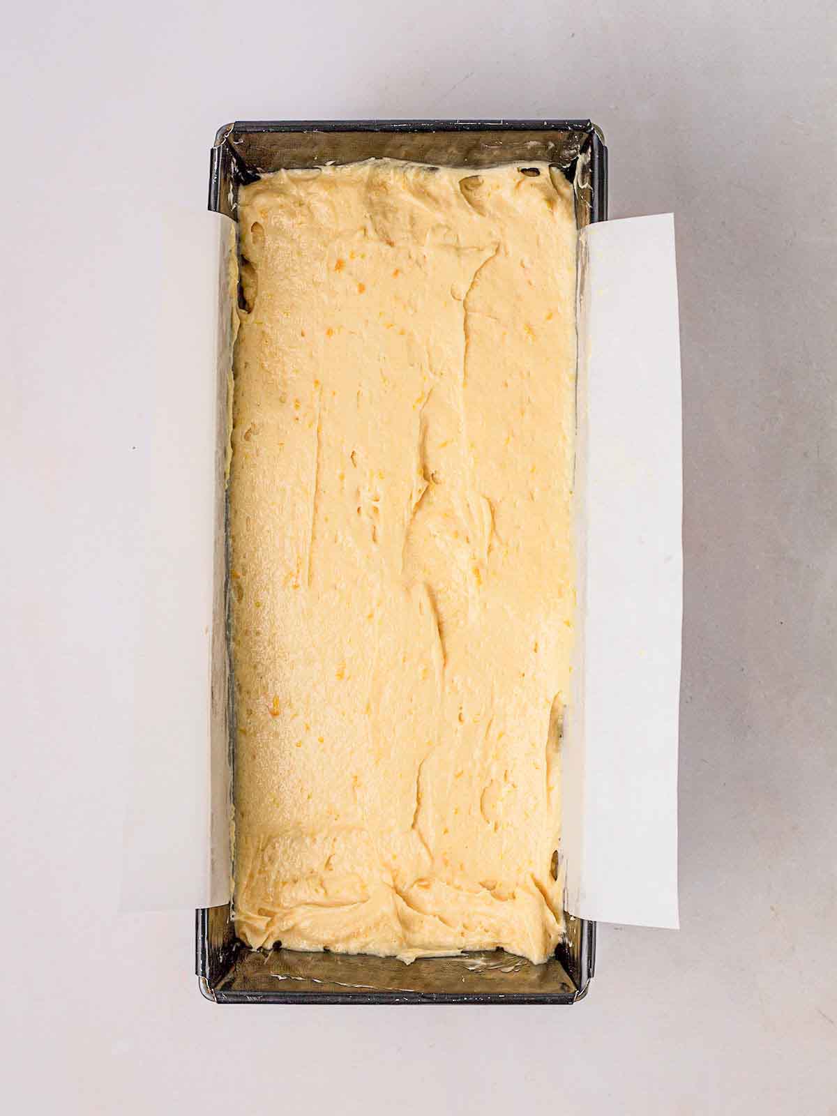 A lined loaf tin filled with Orange Drizzle Cake mixture, ready to go in the oven.