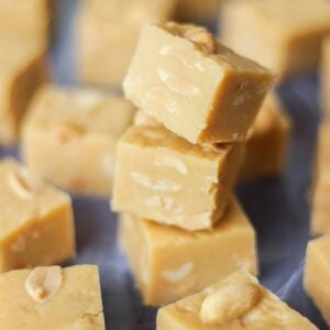 A tray of set peanut butter fudge, with three pieces in a tower.
