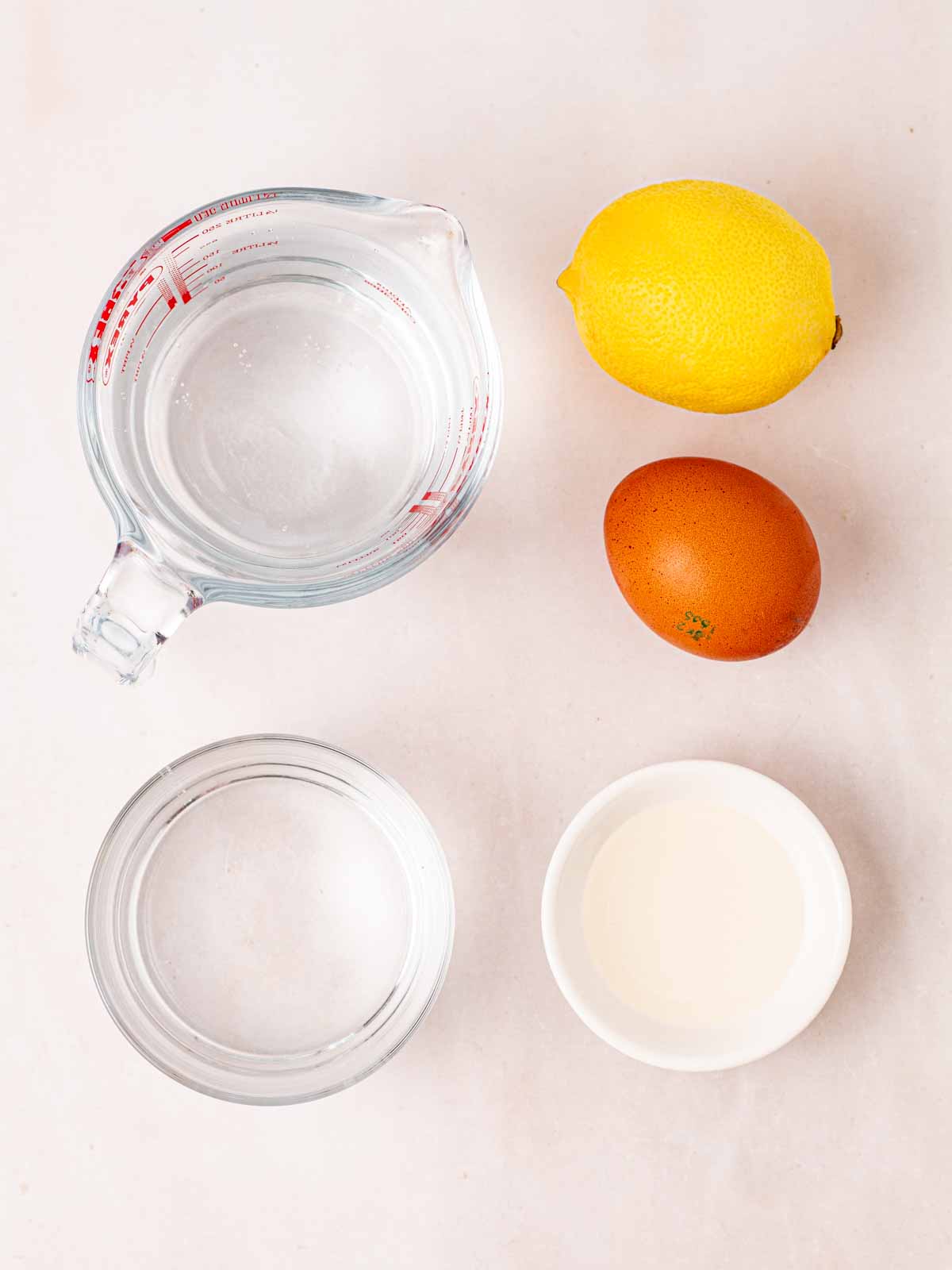 The ingredients for making a Gin Fizz Cocktail laid out on a white counter.
