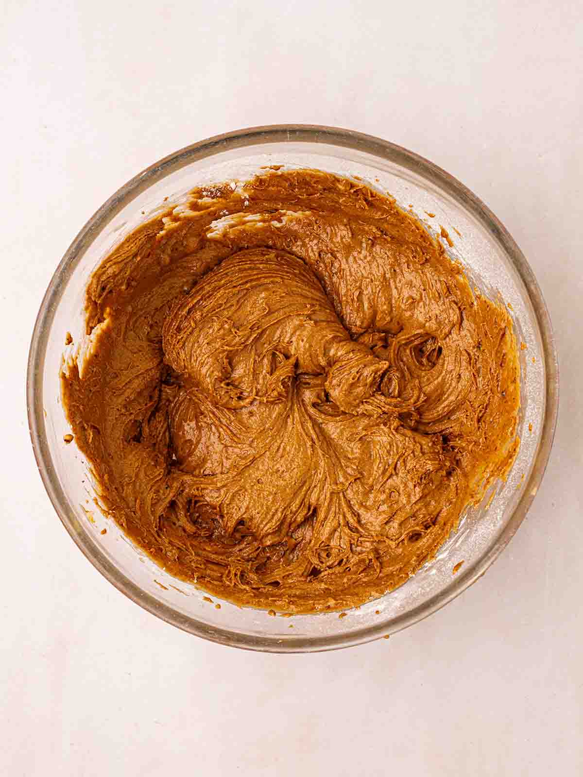 A glass bowl with a brown mixture in for step 2 in the recipe for Slow Cooker Sticky Toffee Pudding.