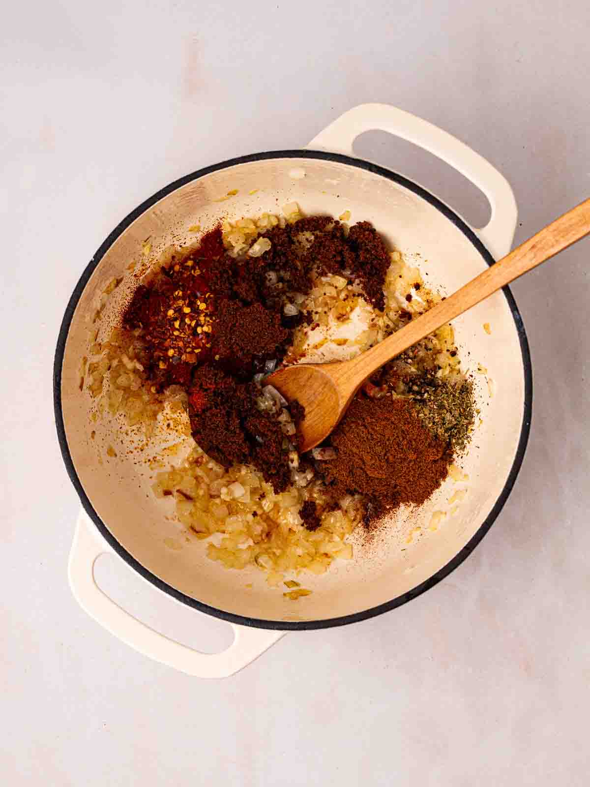 Onions and spices frying in a pan for step 1 in the process for Vegetarian Chilli recipe.