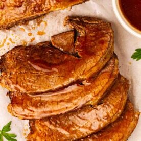 Sliced up beef brisket cooked in the slow cooker with gravy over the top, ready to serve.