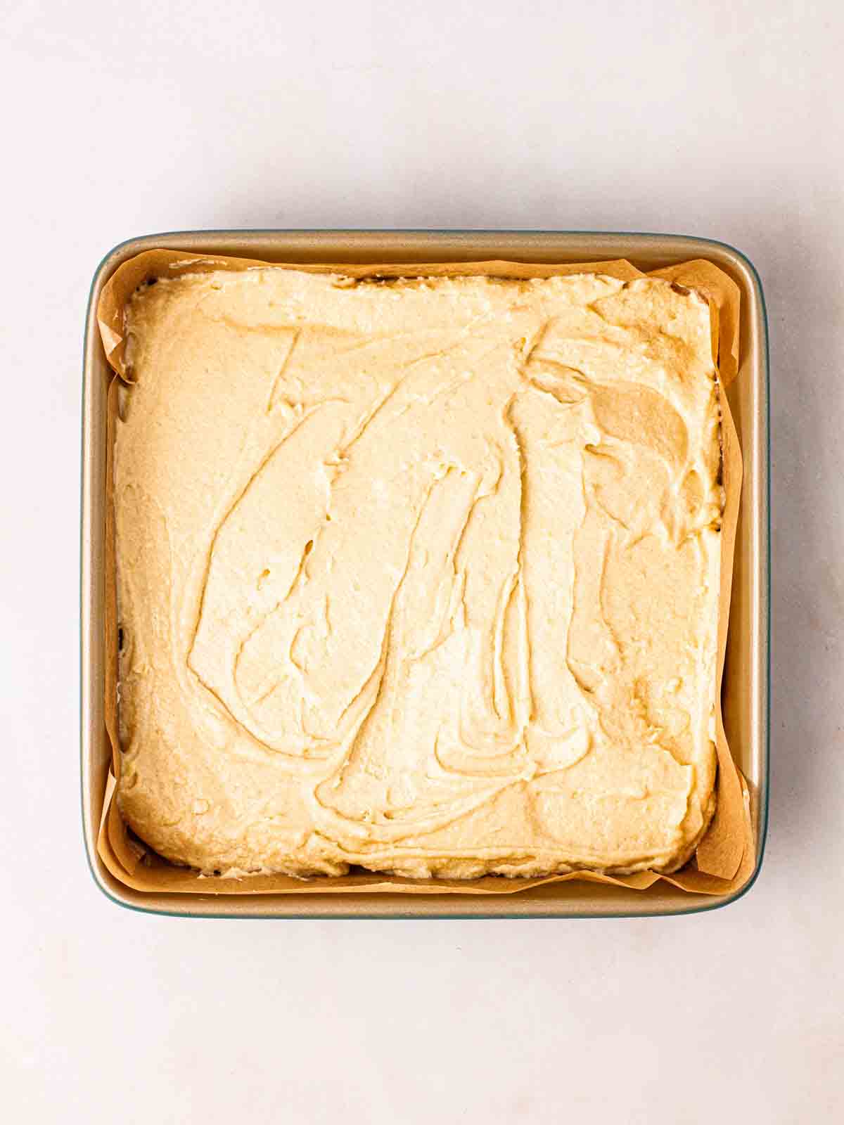 Raw cake mixture in a square dish, ready to be baked.