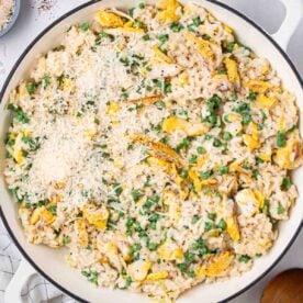 A pan filled with risotto, with peas, smoked haddock and cheese.