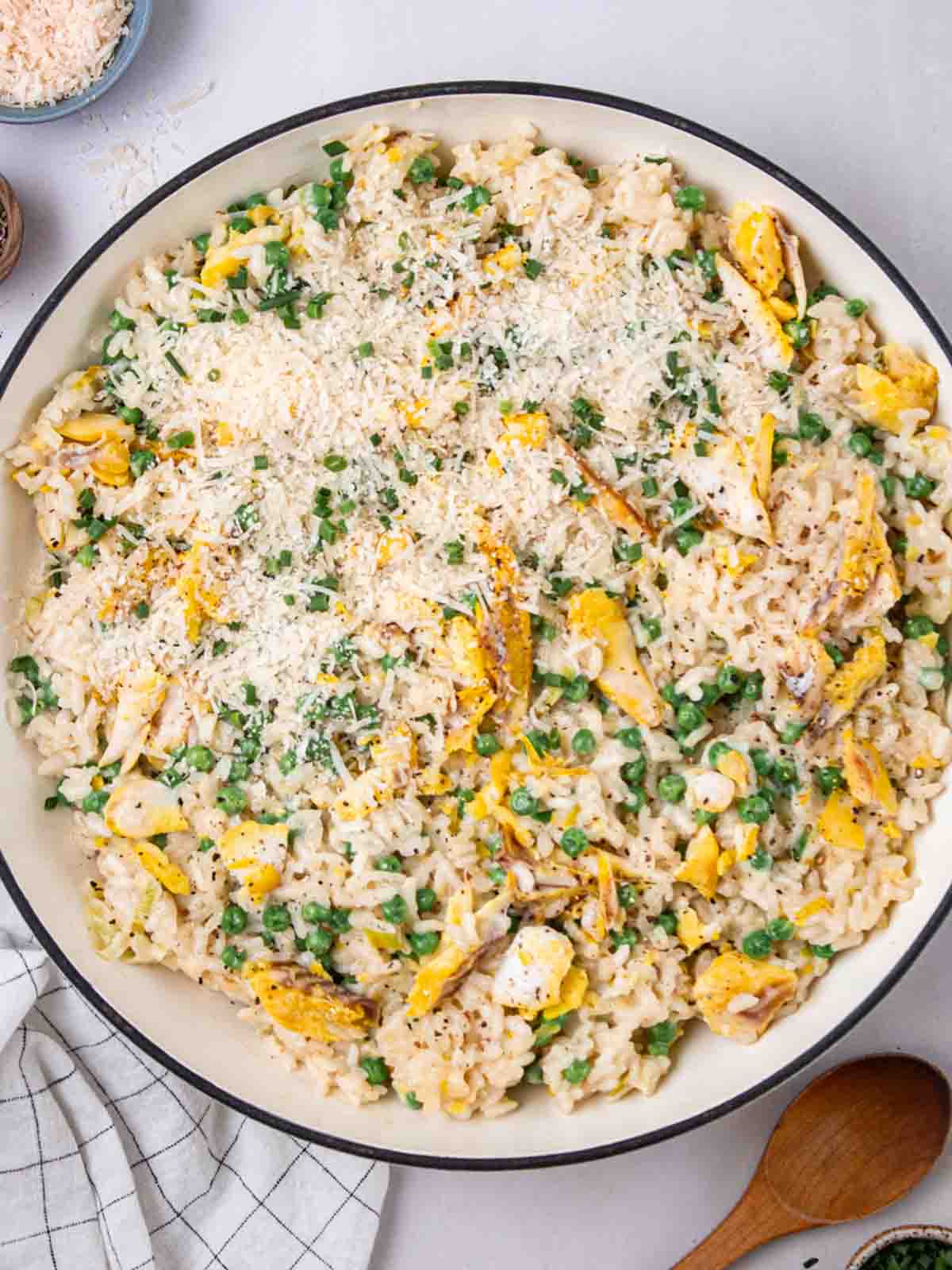 A large pan filled with cooked Smoked Haddock Risotto with peas and cheese over the top.