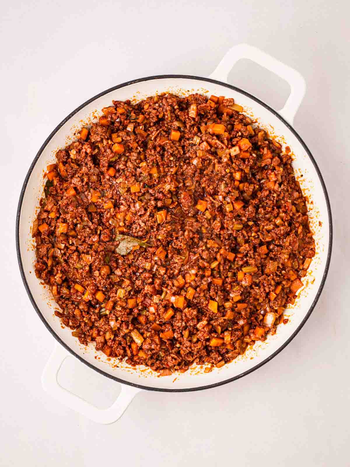 A large white pan with a bolognese sauce inside, ready to serve, for step 6 in the recipe for Spaghetti Bolognese.