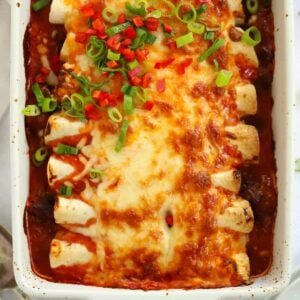 A close up of Beef Enchiladas, straight out of the oven with melted cheese on top.