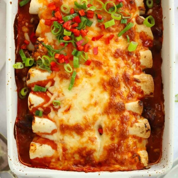 A close up of Beef Enchiladas, straight out of the oven with melted cheese on top.