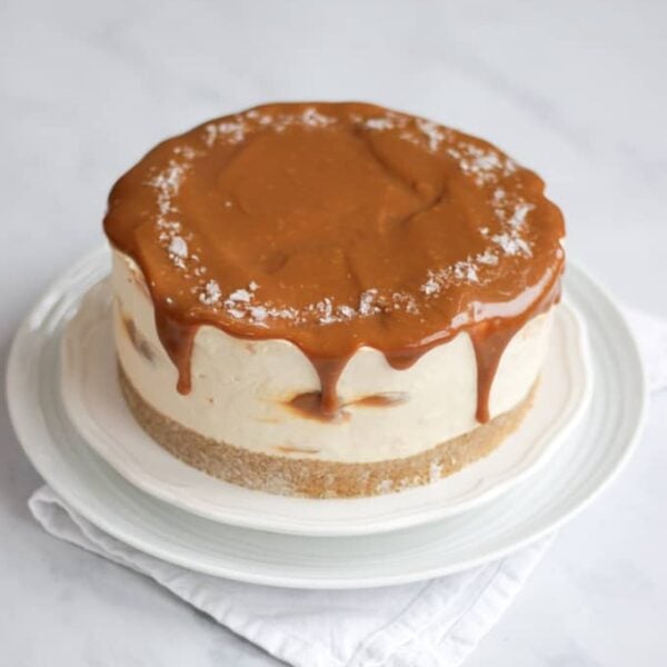 A creamy, rich Salted Caramel Cheesecake on a white plate.