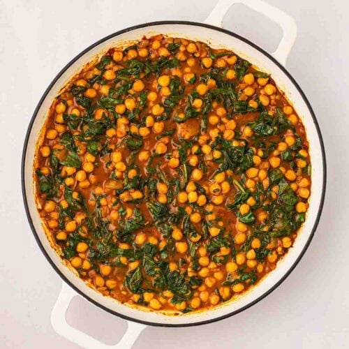 Spinach in a Chickpea Curry, cooked in a white pan.