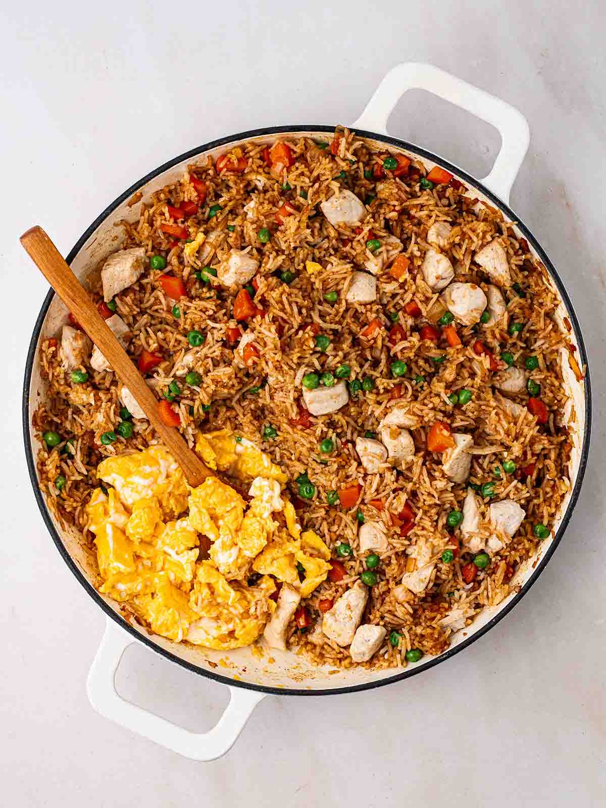 Chicken Fried Rice cooking in a pan, with egg cooking at the side to turn it into Egg Fried Rice.