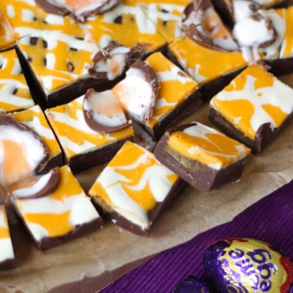 Squares of Creme Egg Fudge on a baking tin, ready to eat.