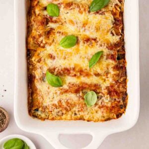 A baked Spinach and Ricotta Cannelloni in a white oven dish, ready to eat.