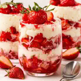 Small glasses with Eton Mess inside, topped with strawberries.