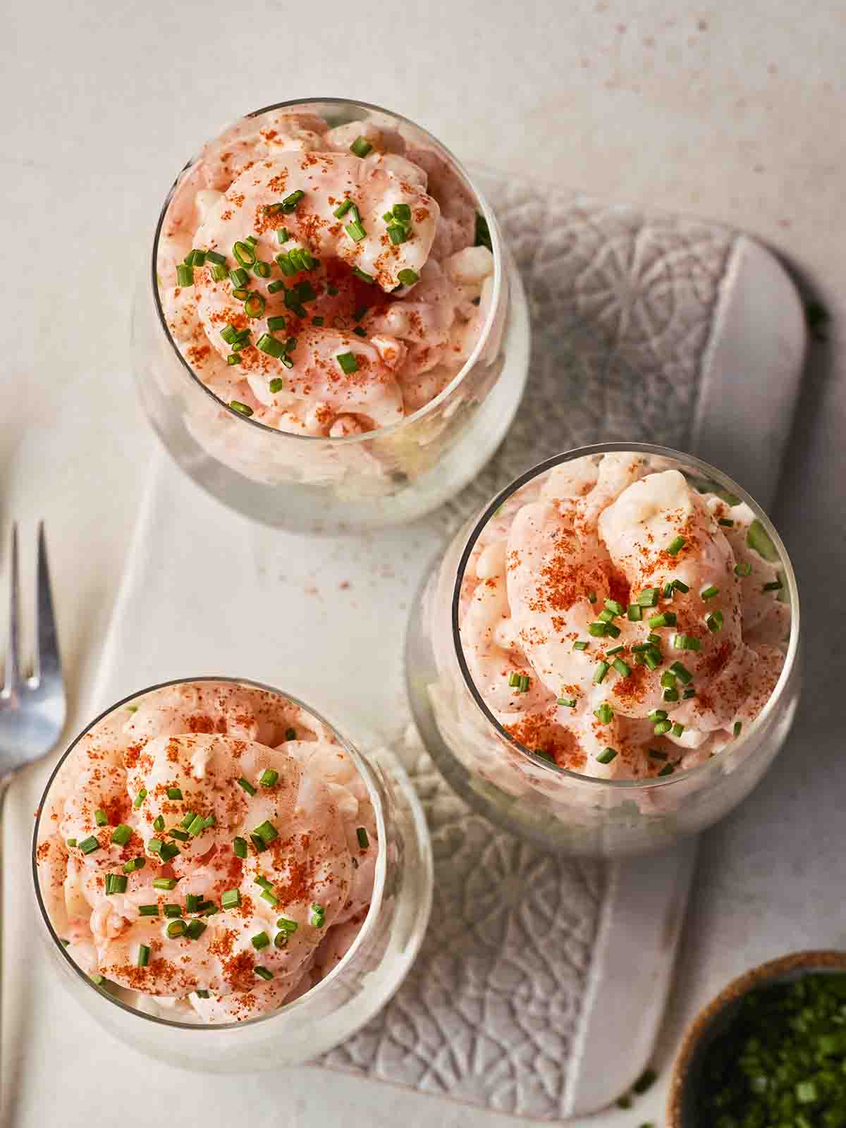 A bird's eye view of three prawn cocktails in glasses, ready to be served.