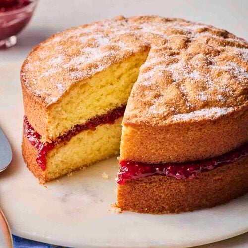 A Classic Victoria Sponge Cake, already with a piece missing.
