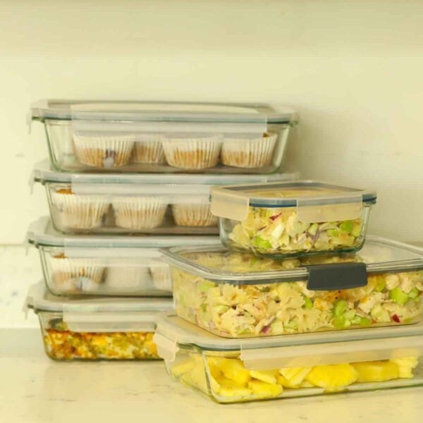 Glass meal prep containers on a counter, filled with lots of made-ahead food for the week ahead.