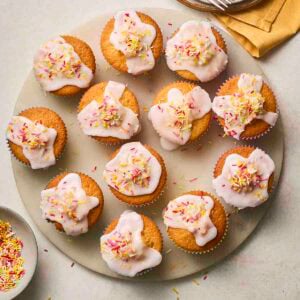 A plateful of iced fairy cakes.