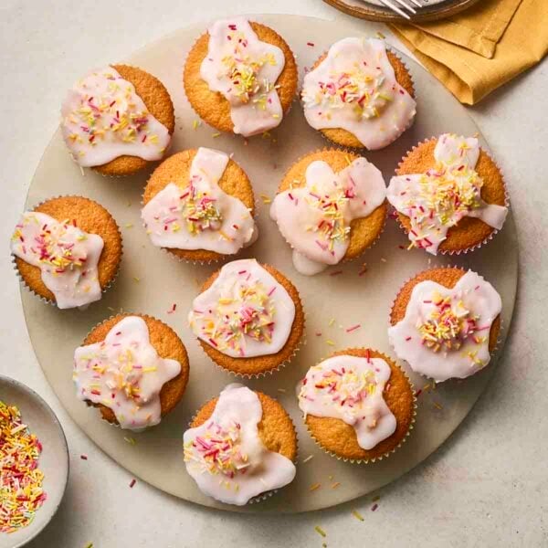 A plateful of iced fairy cakes.