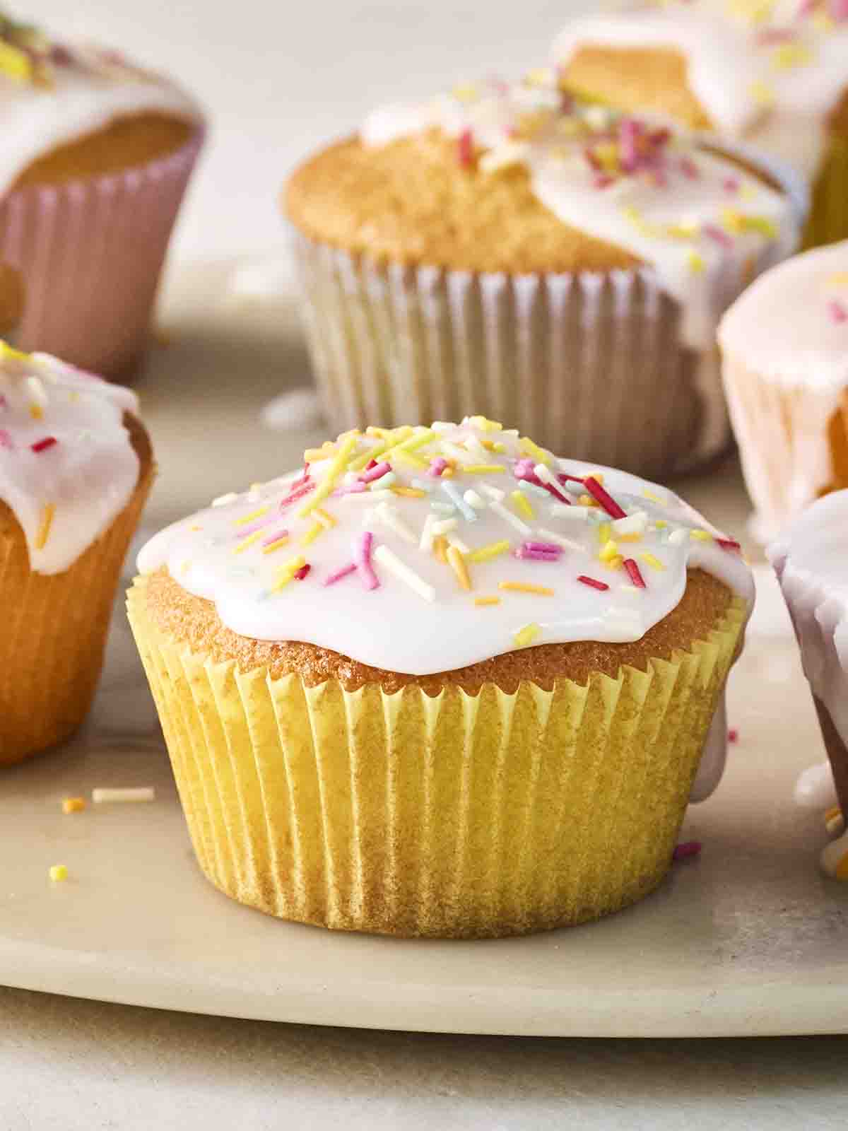 A close up of a decorated fairy cake, with others in the background.