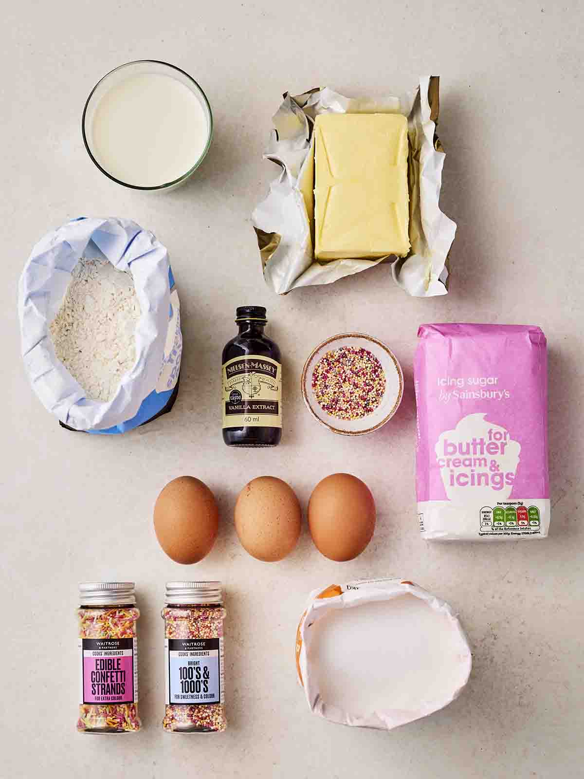 The ingredients for making Fairy Cakes laid out on a white counter.