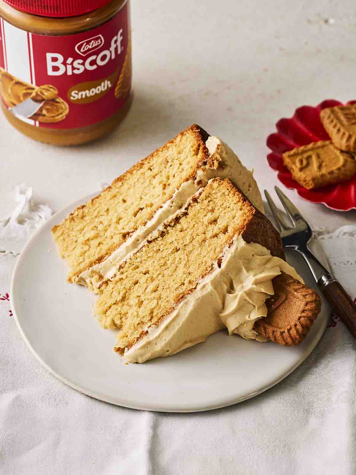 A slice of homemade Lotus Biscoff Cake on a plate, with a cake fork, ready to eat.