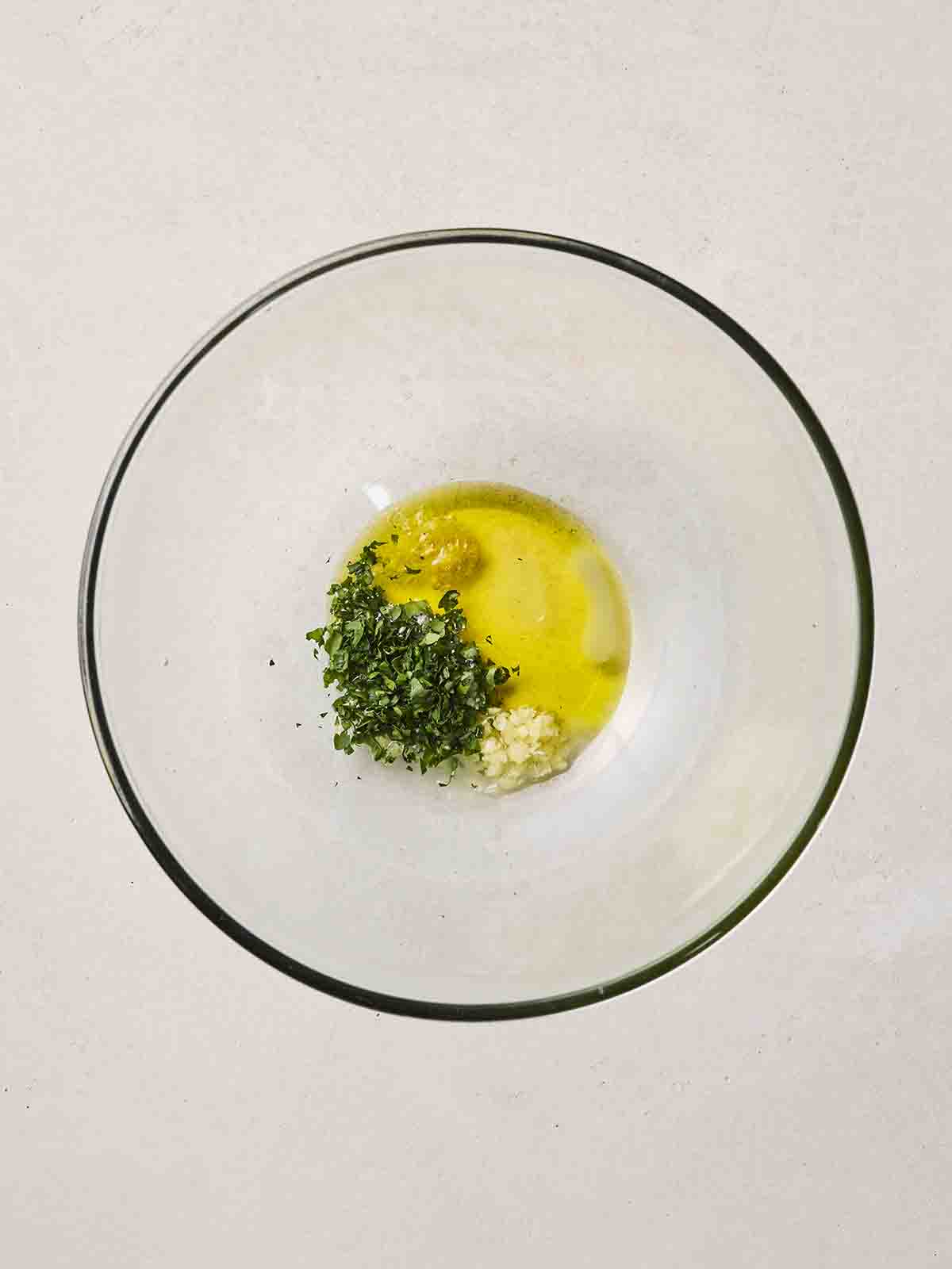 Parsley, garlic and oil in a glass bowl to make up a dressing.