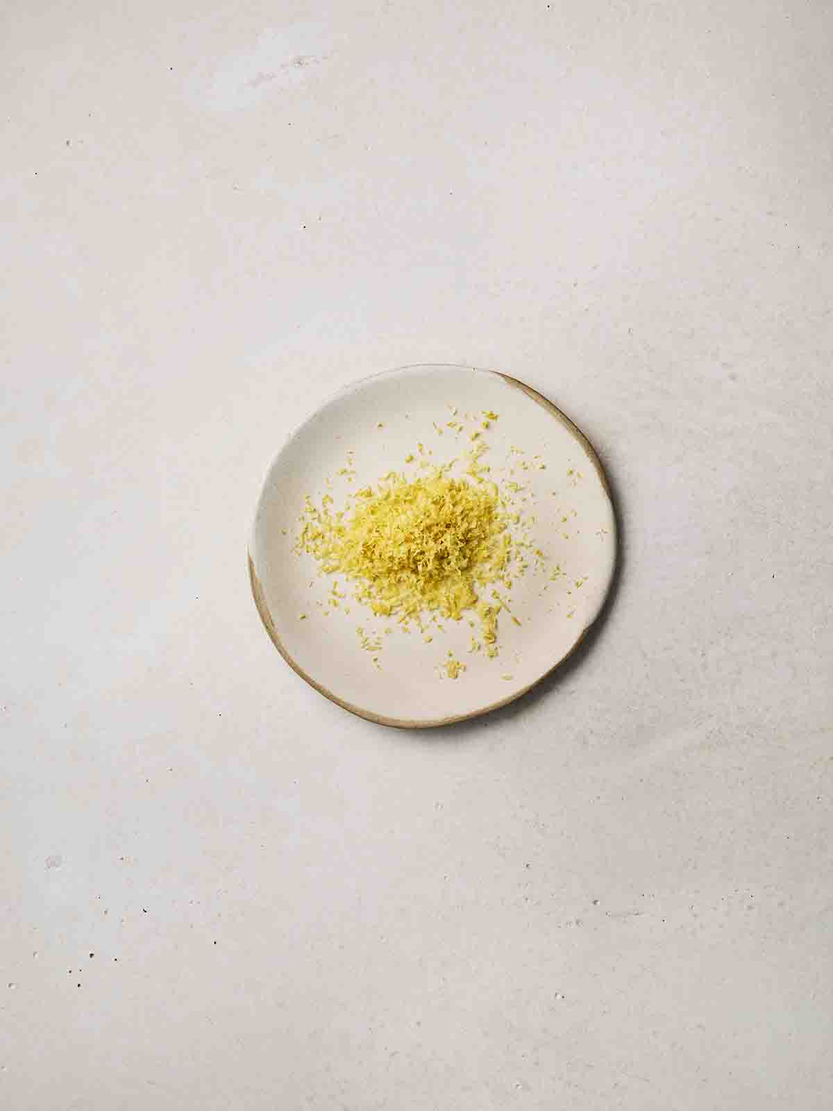 The zest of a lemon on a small white plate.