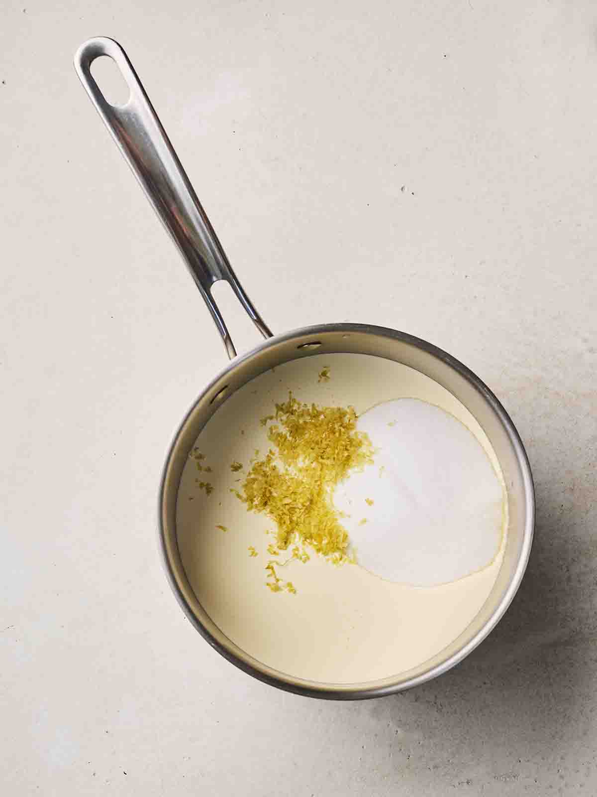 Cream, sugar and lemon zest in a saucepan.