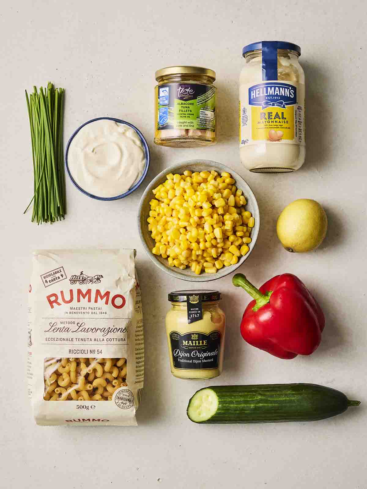 The ingredients for tuna pasta salad laid out on a counter top.