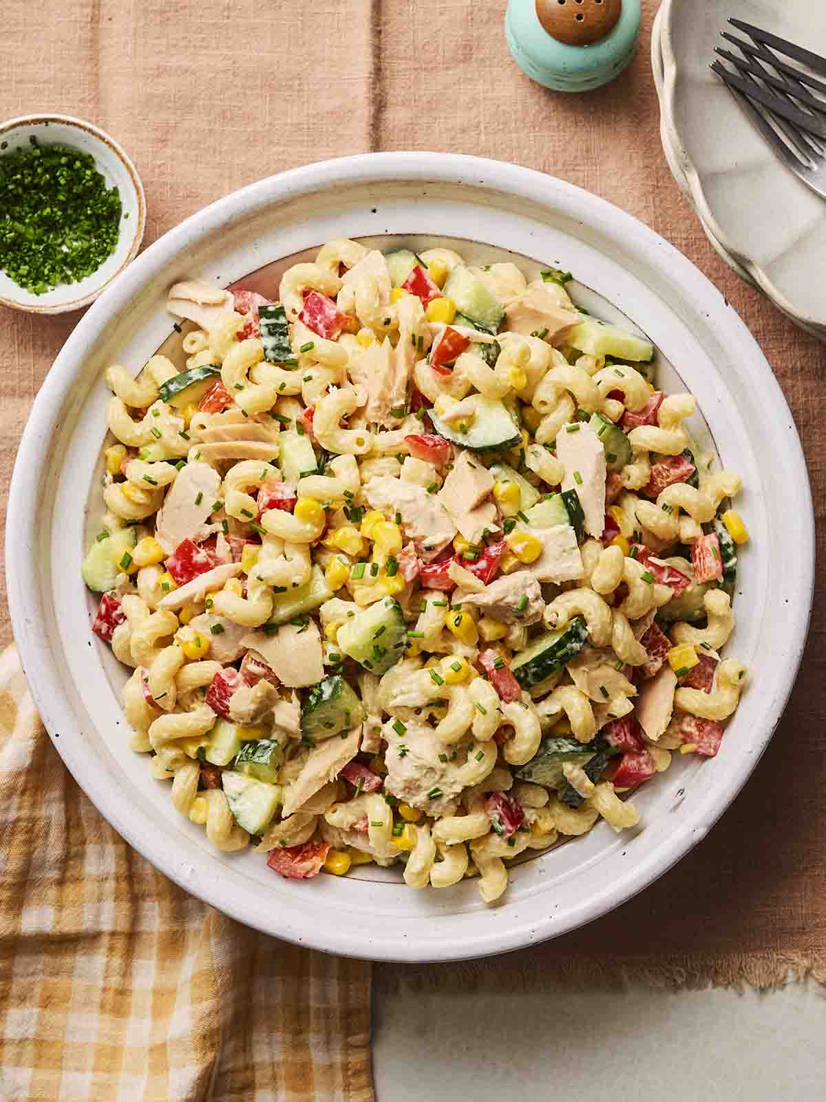 A bowl of tuna pasta salad on a table, ready to eat.