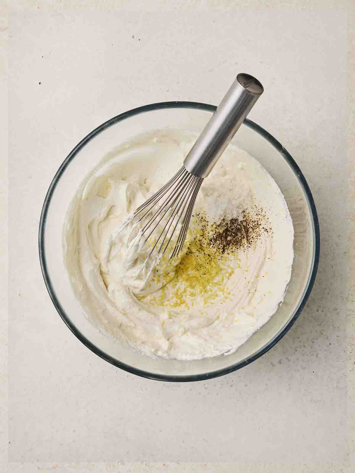 A combination of ricotta and mozzarella being stirred together for a Vegetarian Lasagne.