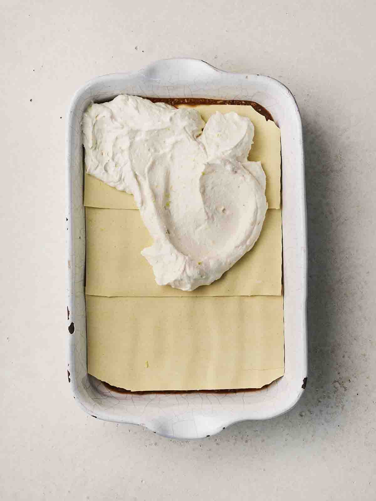 Cheese on top of a veggie lasagne for step 5 in the recipe.