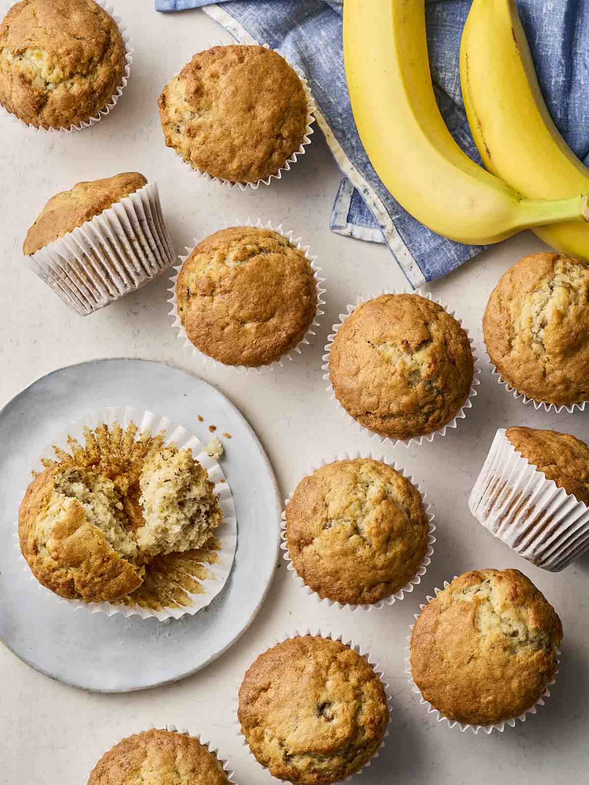Lots of muffins with banana flavour on a table.