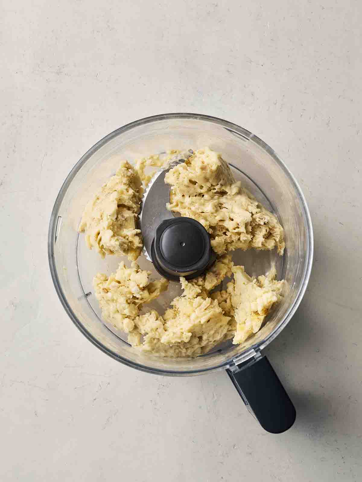A food processor with whizzed up frozen banana inside.