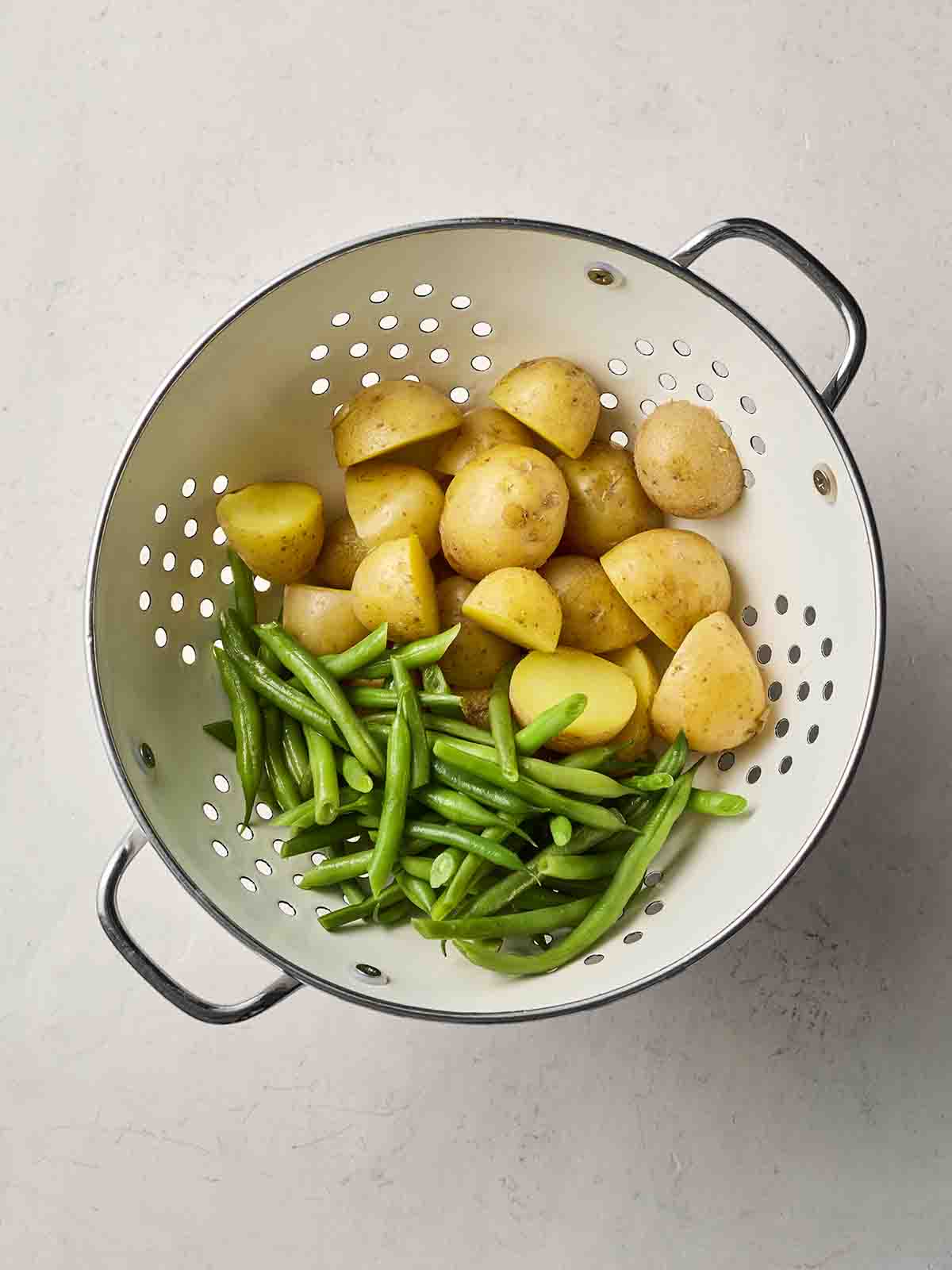 Potatoes and green beans in a colander.